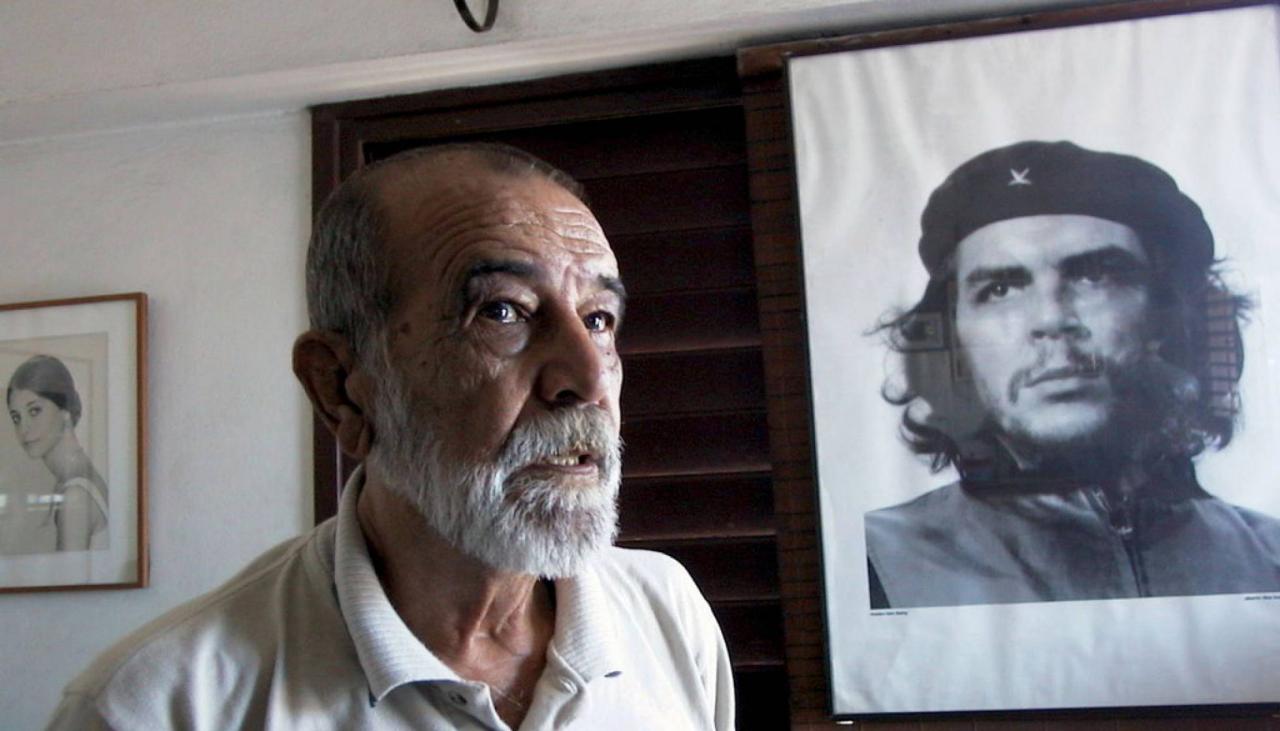 El fotógrafo Alberto Korda posando junto al retrato del Che Guevara en agosto de 2000.