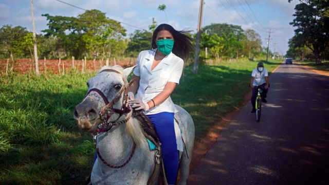 Una trabajadora cubana de la Salud monta un caballo para transportarse.