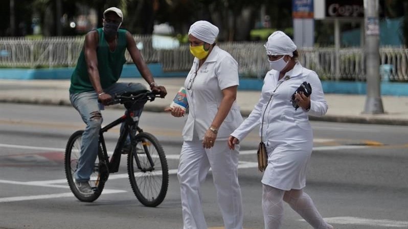 Dos enfermeras cubanas cruzan una calle del Vedado, La Habana.