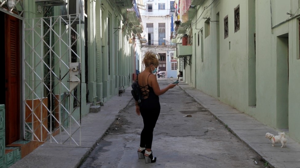 Una mujer consulta su teléfono en una calle de La Habana.