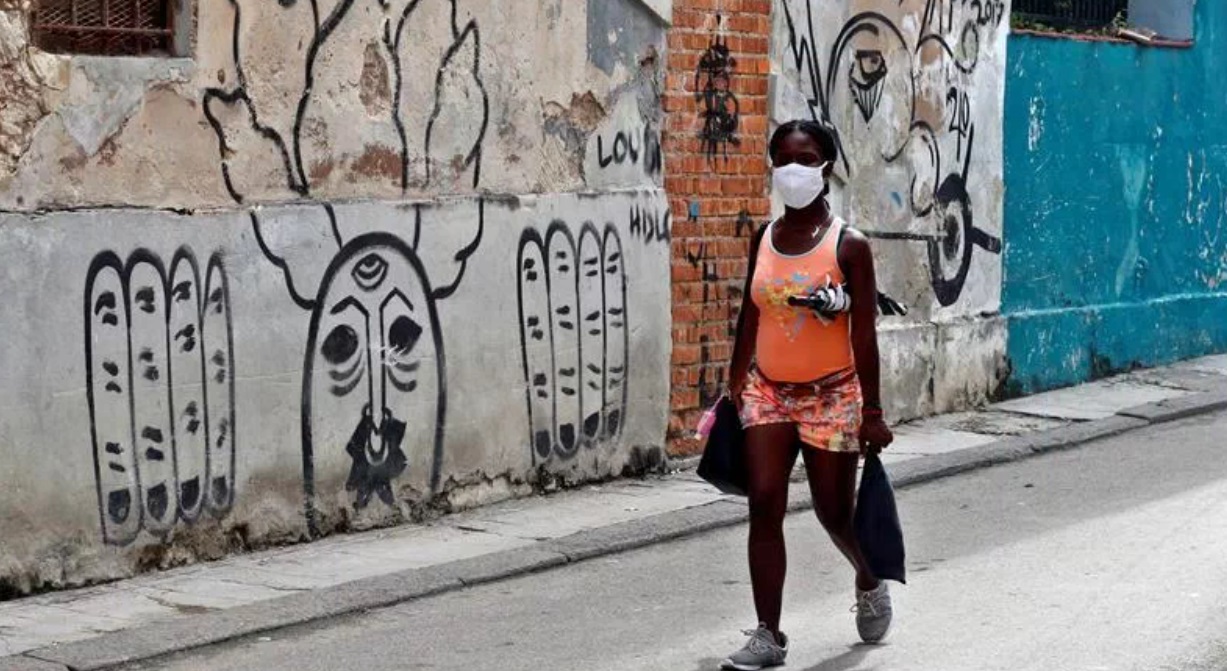 Una cubana con nasobuco camina por una calle de La Habana.