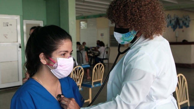 Una doctora cubana atiende a una paciente.