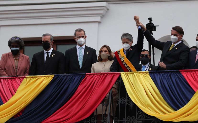 El presidente brasileño Jair Bolsonaro alza el brazo del presidente ecuatoriano Guillermo Lasso en su toma de possesión.