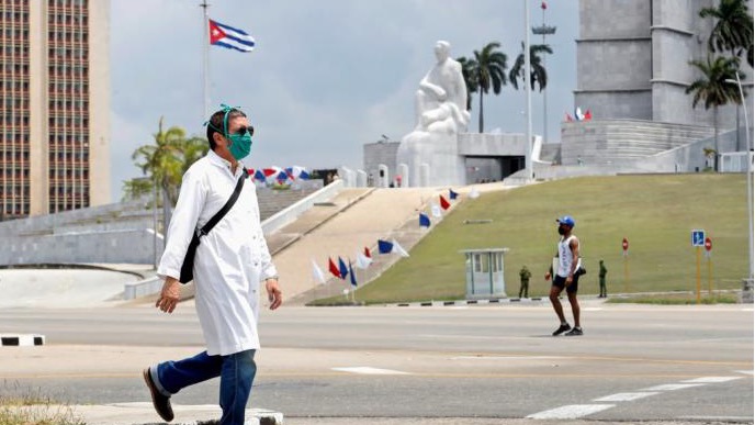 Un médico cubano camina frente a la Plaza de la Revolución.