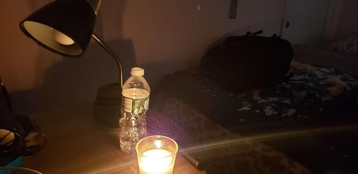 Una habitación iluminada con una vela durante un apagón.