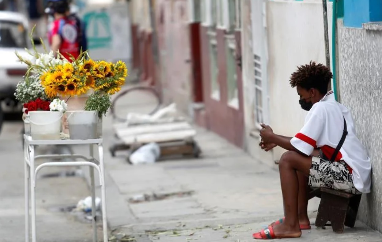 Un niño vigila un puesto de venta de flores en La Habana.