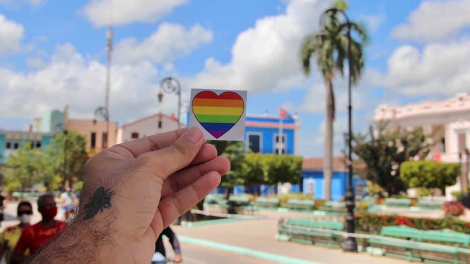 Un activista muestra un sticker de la campaña Colorear Cuba.