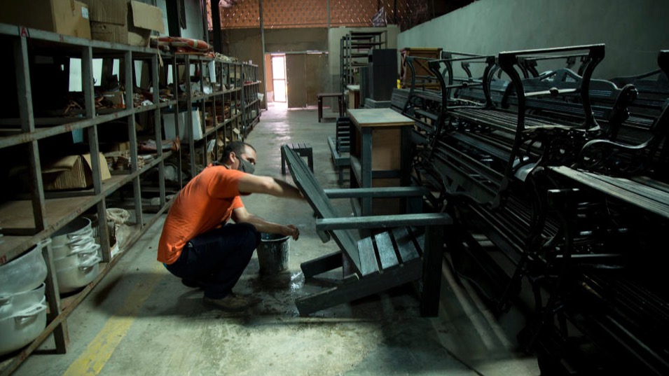 Un trabajador de la Cooperativa Atres limpia muebles hechos de plástico o madera ecológica.