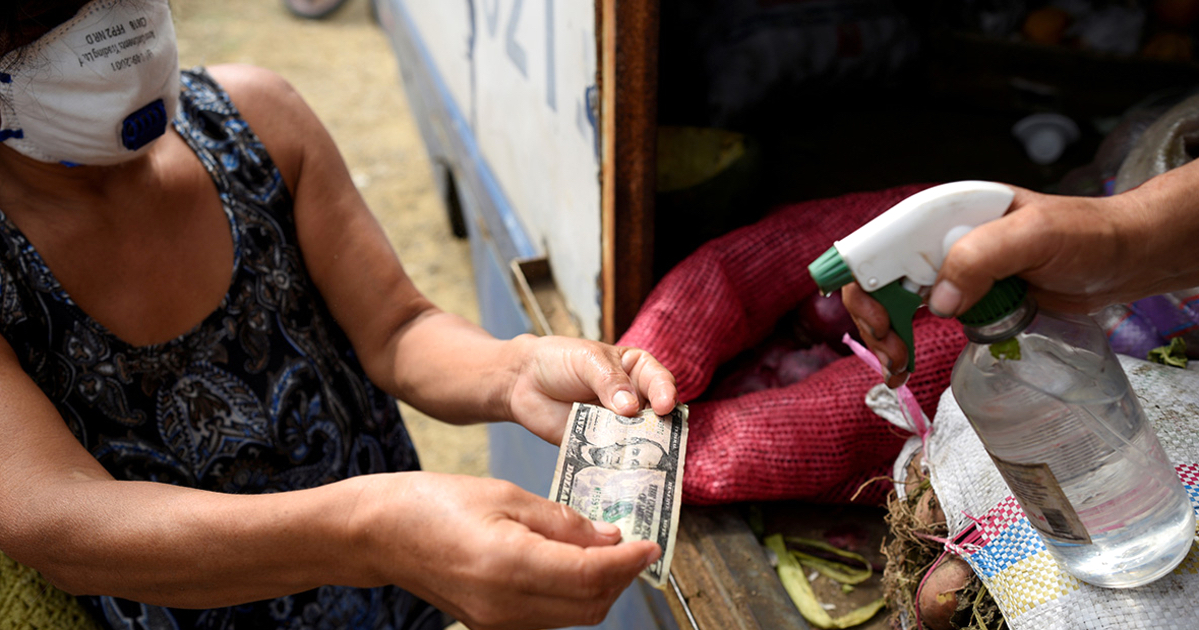 Una cubana muestra un billete de la moneda estadounidense en La Habana.