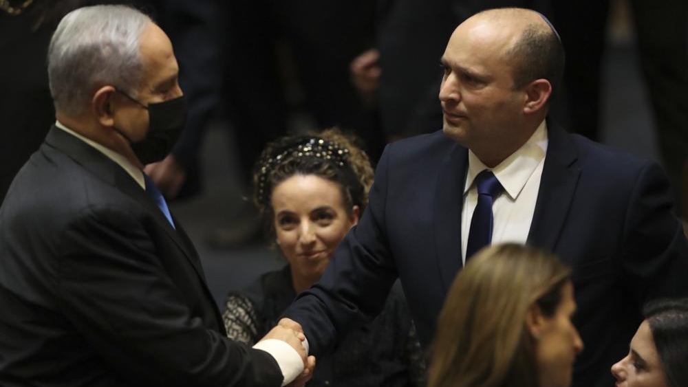 Benjamin Netanyahu le da la mano al nuevo primer ministro de Israel, Naftali Bennett.