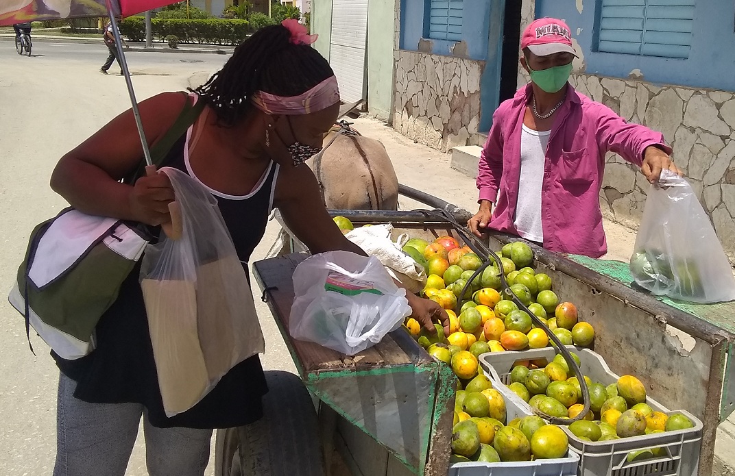 Una mujer compra mangos en Santiago de Cuba