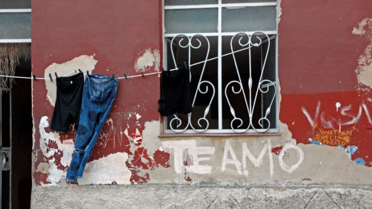 Una tendedera de ropa y en cartel en una vivienda en La Habana.
