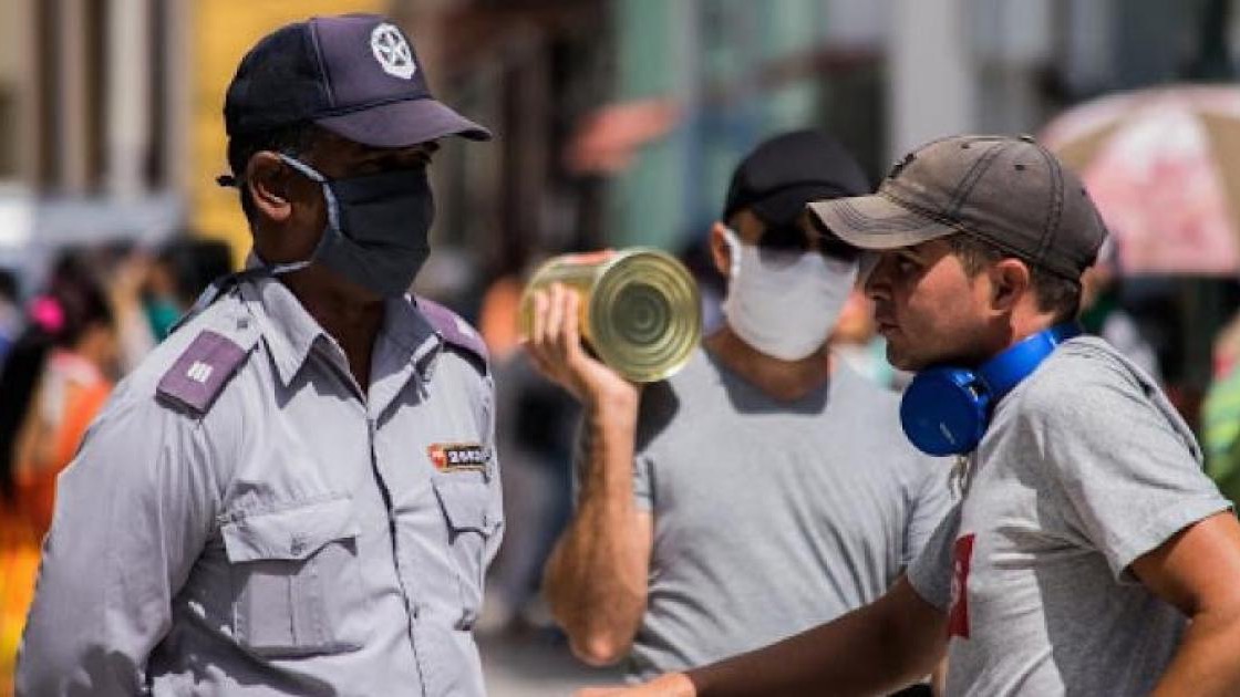 Un policía cubano detiene a un hombre sin nasobuco.
