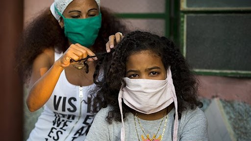 Dos jóvenes cubanas con nasobuco.