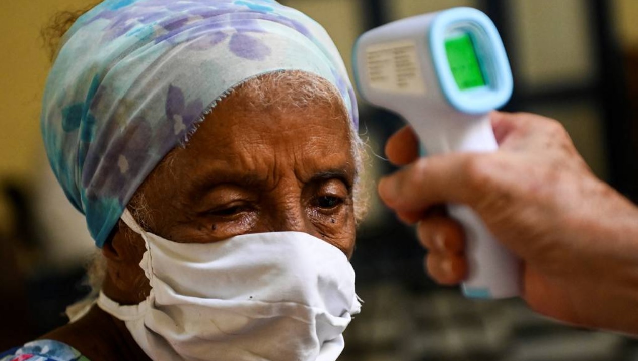 Una anciana cubana sometida a toma de temperatura.