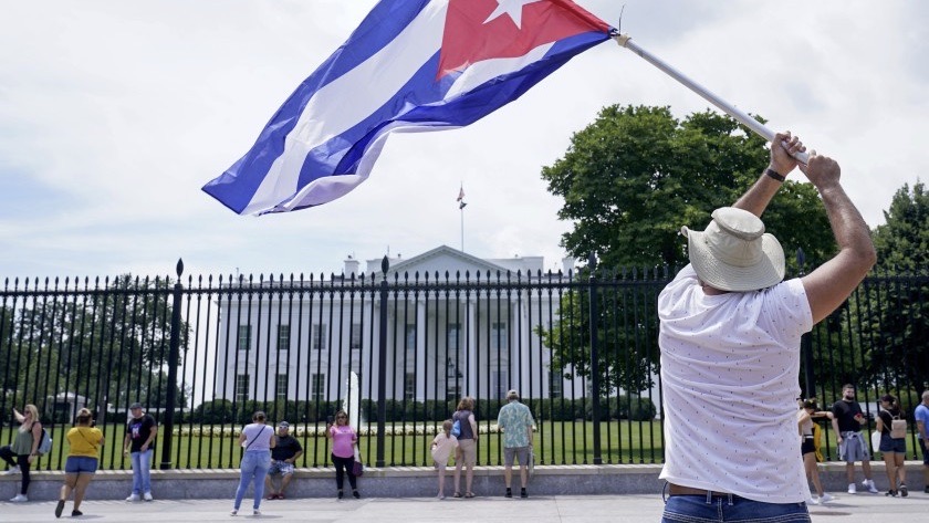 A man with a Cuban flag in front of the White House.