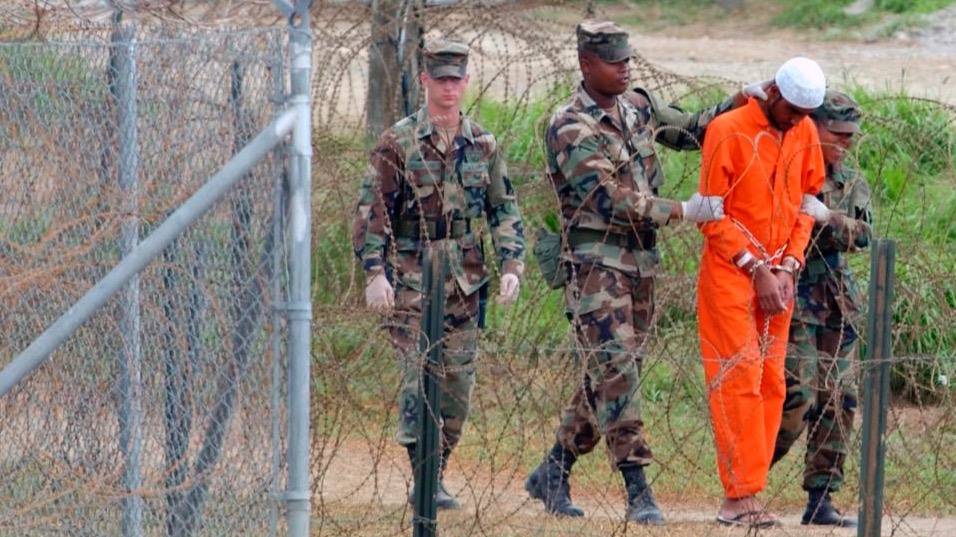 Un detenido llevado por la policía militar a un interrogatorio en el Campamento Rayos X de la Base Naval de Guantánamo en 2002. 