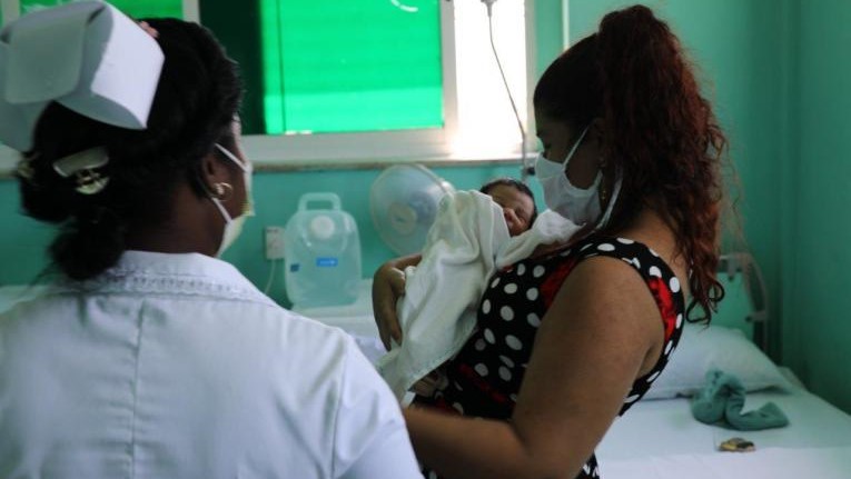 Una mujer recién parida con su bebé en un hospital de Cuba.