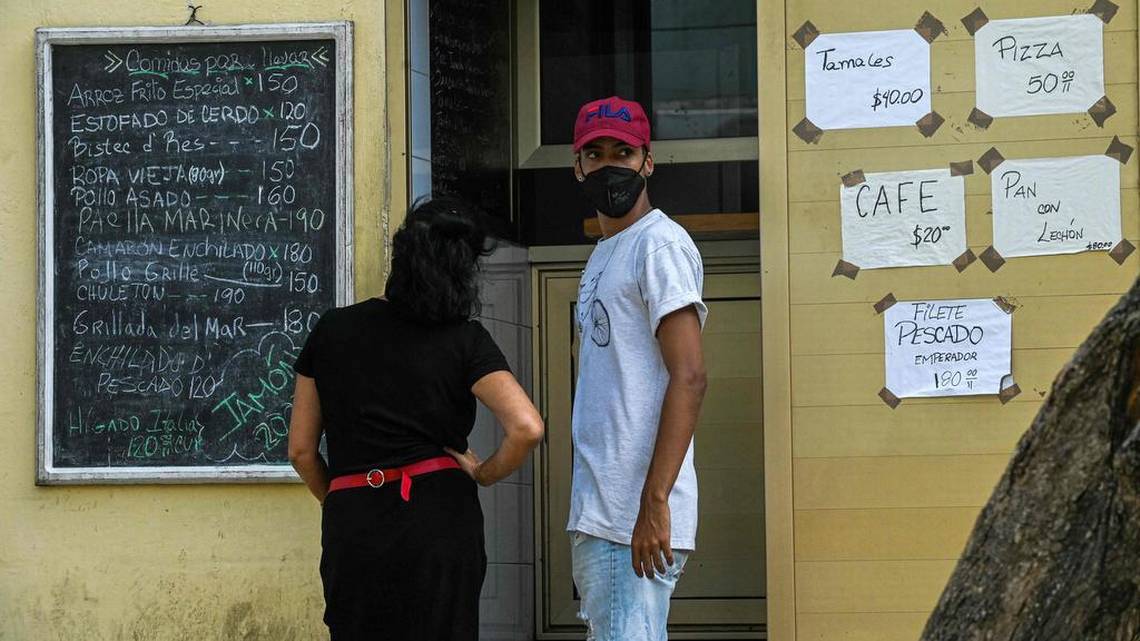 Cubanos esperan sus pedidos en un restaurante privado de La Habana.