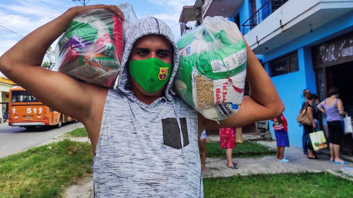 Un cubano carga con un módulo de alimento entregado por el Gobierno de las donaciones.