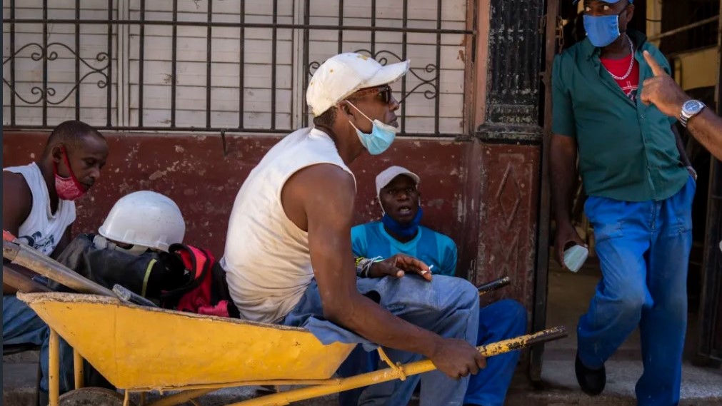 Obreros cubanos conversan en una acera en La Habana.