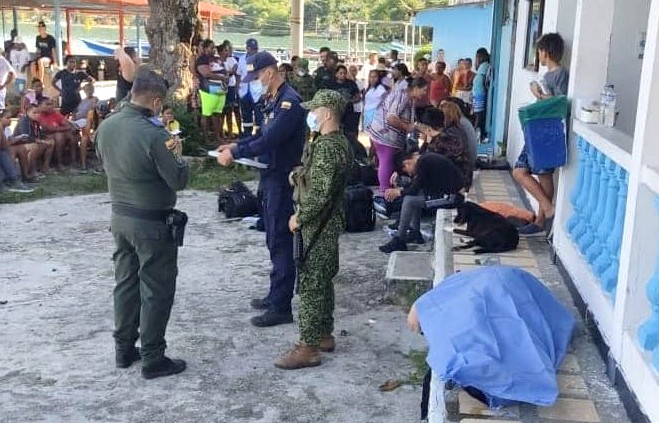Autoridades colombianas junto a uno de los cuerpos rescatados en el mar.