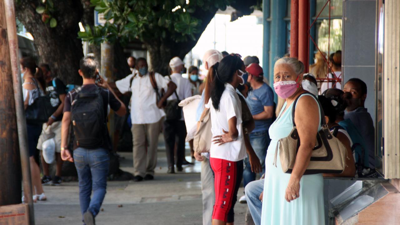 Varias mujeres en una parada de guagua en La Habana.