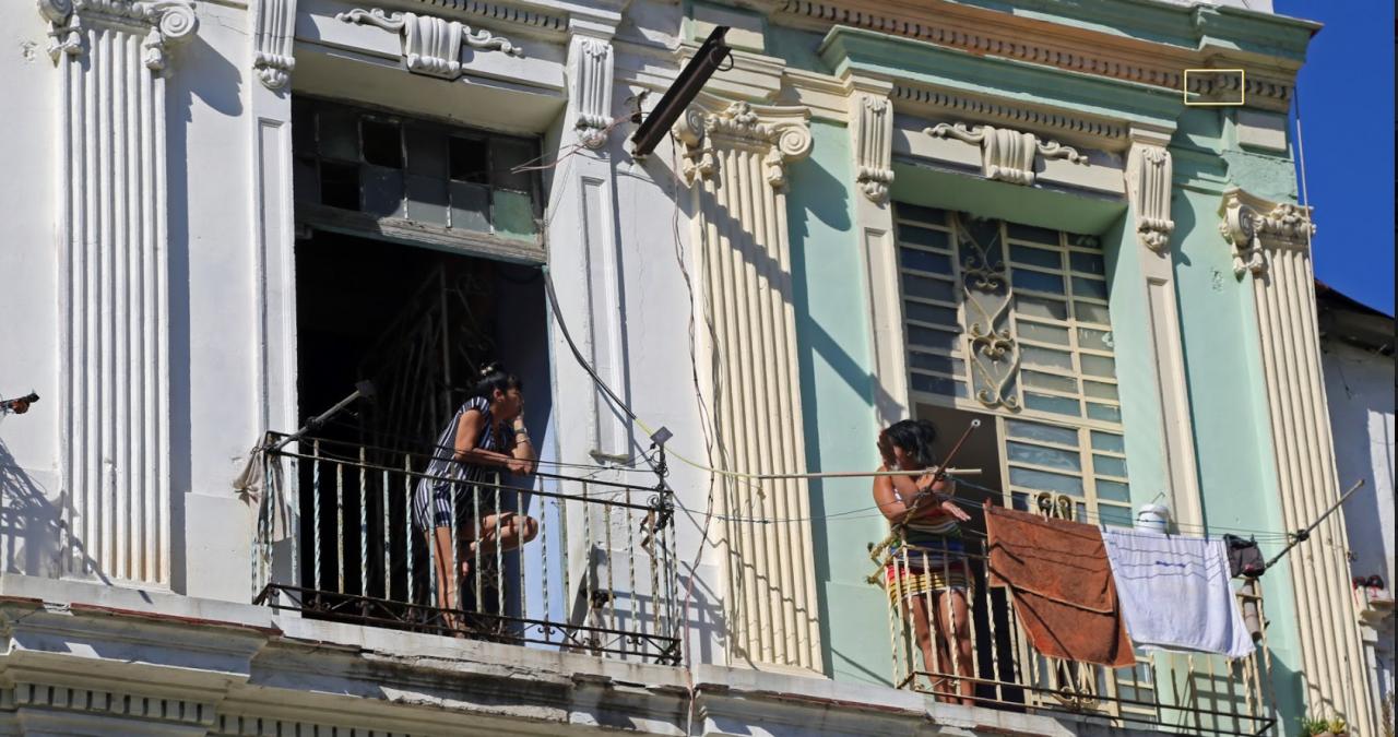 Dos mujeres cubanas conversan desde sus balcones en La Habana.