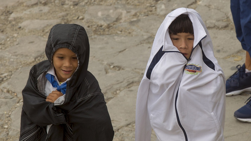 Do niños cubanos con abrigos.