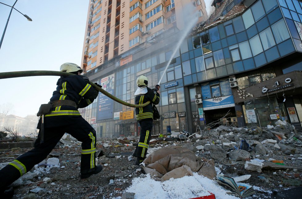 Bomberos apagan un incendio causado por obuses en edificios civiles de Kiev.
