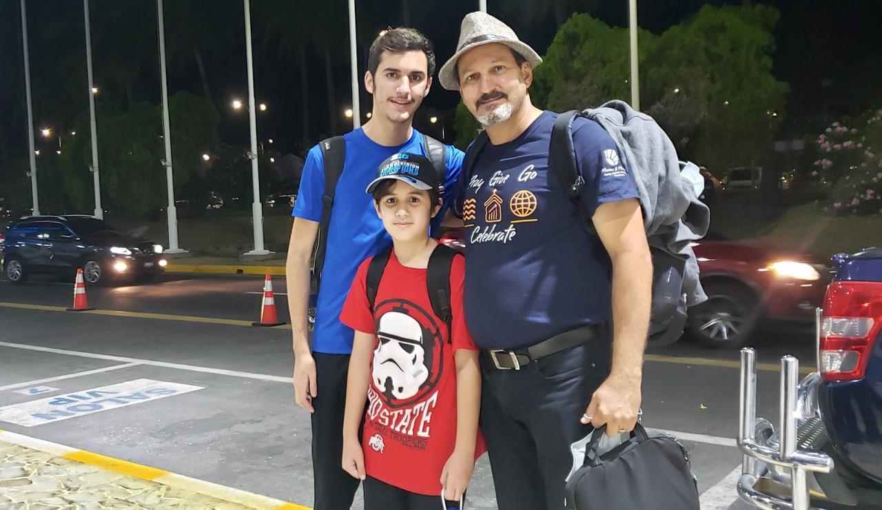 El pastor cubano Carlos Sebastián Hernández Armas y sus dos hijos, tras salir del aeropuerto de San Salvador.