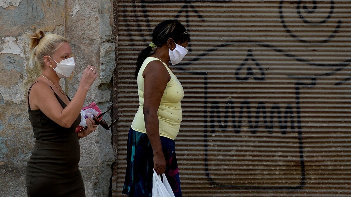 Dos mujeres caminan el martes por una calle de La Habana usando máscaras para evitar la propagación del coronavirus.
