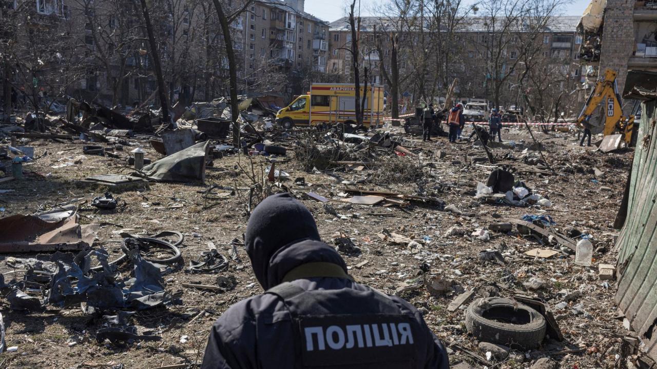 Un policía ucraniano asegura una zona en Kiev tras un ataque ruso.