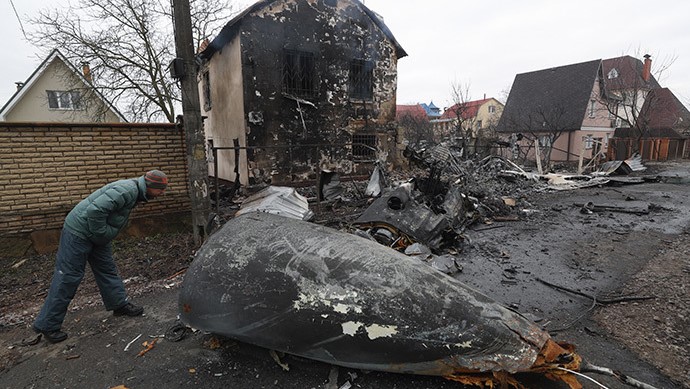 Un hombre observa los restos de un avión militar derribado en la región de Kiev.