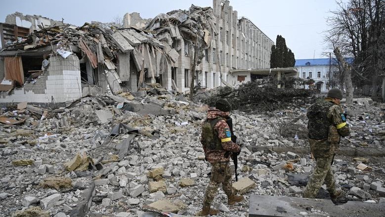 Oficiales ucranianos caminan cerca de un edificio escolar destruido por bombardeos en Zhytomyr, el 4 de marzo.