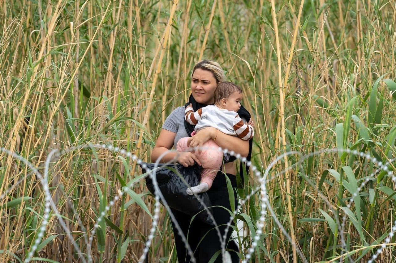 Madre con su bebé intenta cruzar la frontera.