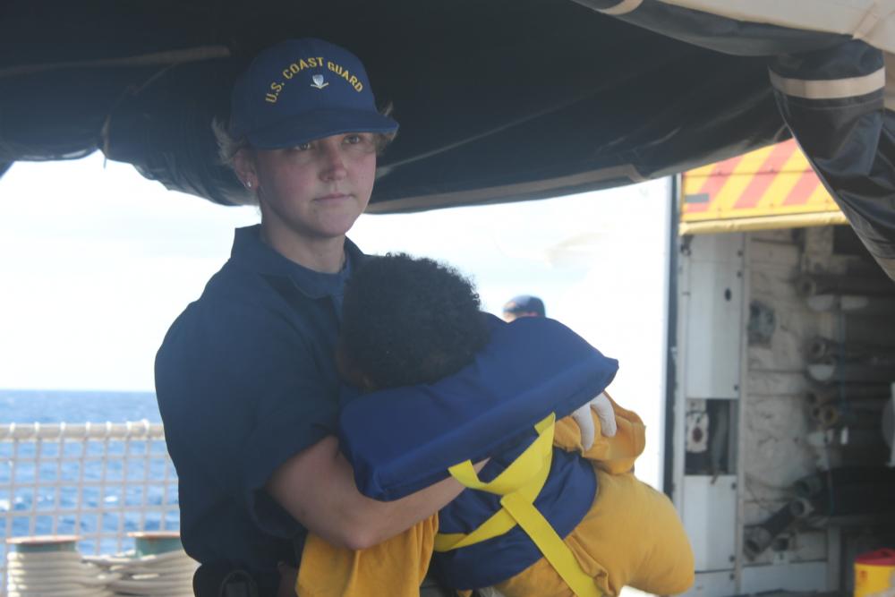 Guardacostas de EEUU con una niña rescatada en el mar.