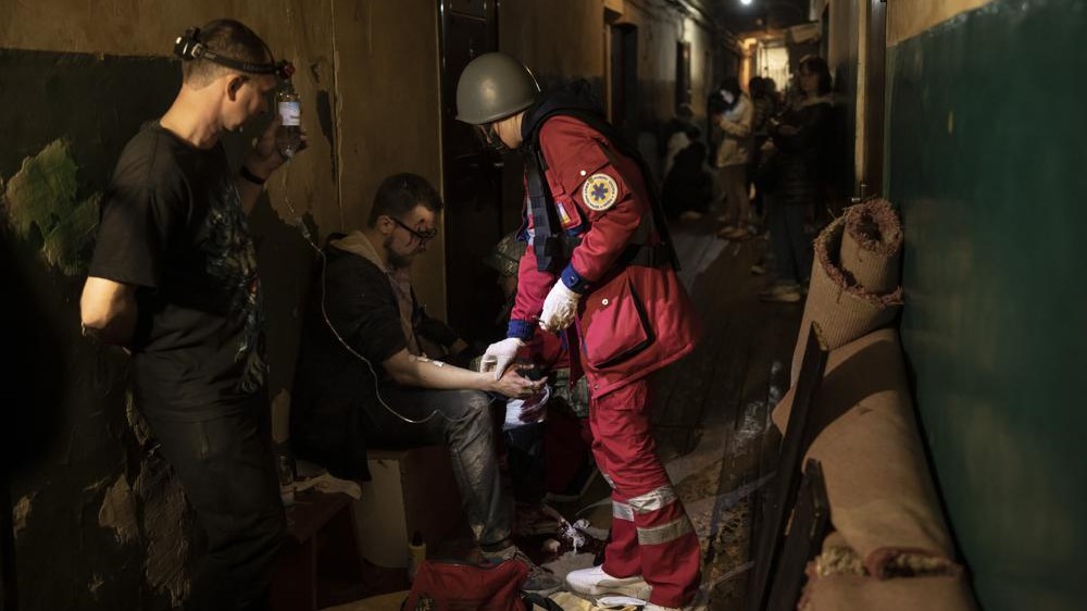 Vadim Krikun recibe tratamiento en el pasillo de su edificio de apartamentos después de un ataque ruso en Jarkov, Ucrania, el 15 de abril.