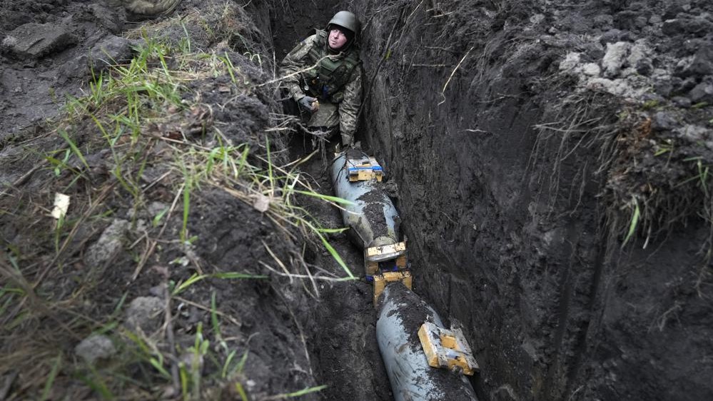 Un zapador ucraniano se prepara para detonar una bomba aérea rusa de 250 kilogramos en la aldea de Kolonshchyna, Ucrania, 21 de abril. 