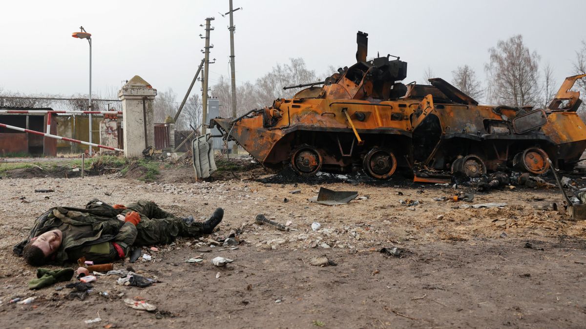 El cadáver de un soldado ruso yace en el suelo frente a un vehículo blindado ruso BTR-82 destruido, en el pueblo de Nova Basan, Ucrania.