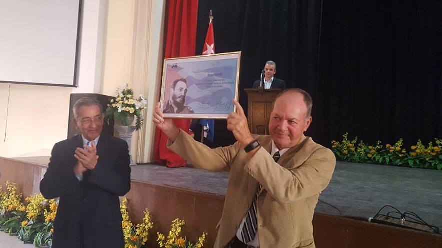 Juan Vela Valdés sostiene un diploma con la imagen de Fidel Castro en un reconocimiento del Gobierno en 2019.