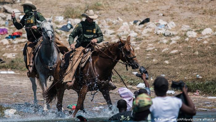 Guardias fronterizos de Estados Unidos ahuyentan a los migrantes con látigos.