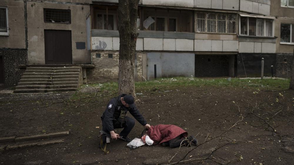 Un oficial de policía revisa el cuerpo de una mujer muerta durante un bombardeo ruso en un barrio en Jarkov, Ucrania, el 19 de abril.