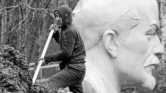 Un hombre cava en el memorial de la cabaña de Lenin en Razliv.