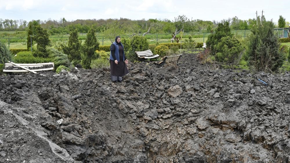 La hermana ortodoxa Evdokia frente al cráter de una explosión, luego de un bombardeo ruso junto a un templo ortodoxo en Adamivka, cerca de Slovyansk, Donetsk, Ucrania, 10 de mayo de 2022.