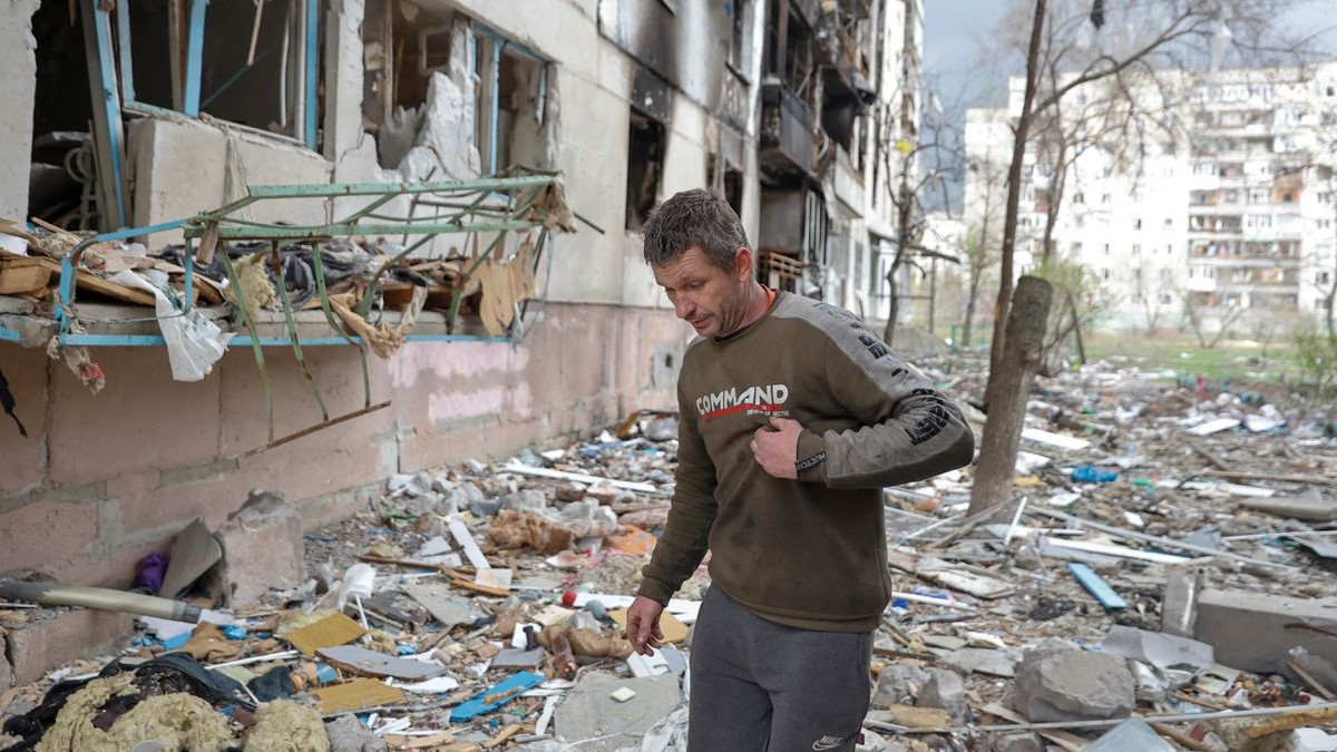 Un residente local camina sobre los escombros de un edificio residencial dañado por un ataque militar.