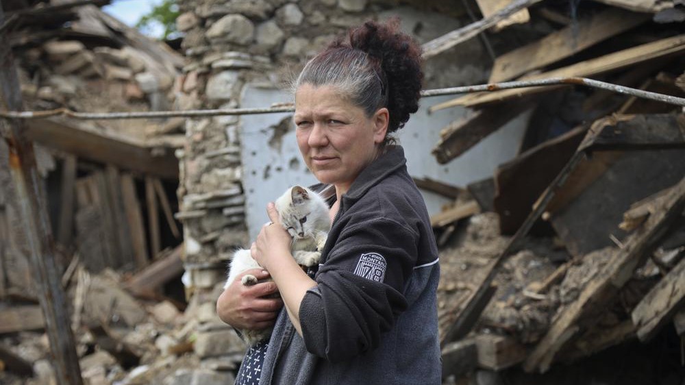 Una mujer junto a una casa destruida en Mariupol, en el este de Ucrania, el martes 17 de mayo de 2022.