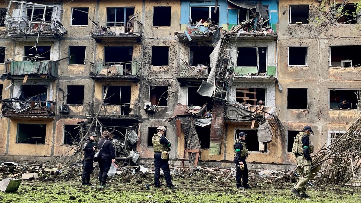 Personal militar ucraniano inspecciona el sitio de un ataque con misiles frente a un edificio residencial dañado en Dobropillia.