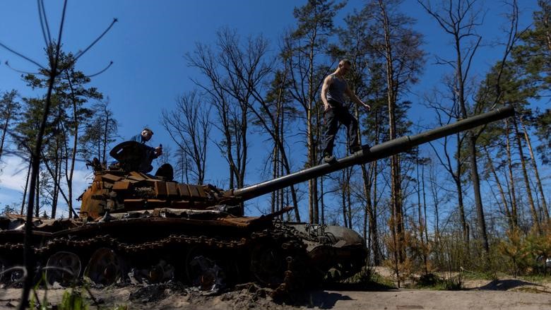 Residentes locales se suben a la cima de un tanque ruso destruido cerca de Irpin, Ucrania, el 6 de mayo.