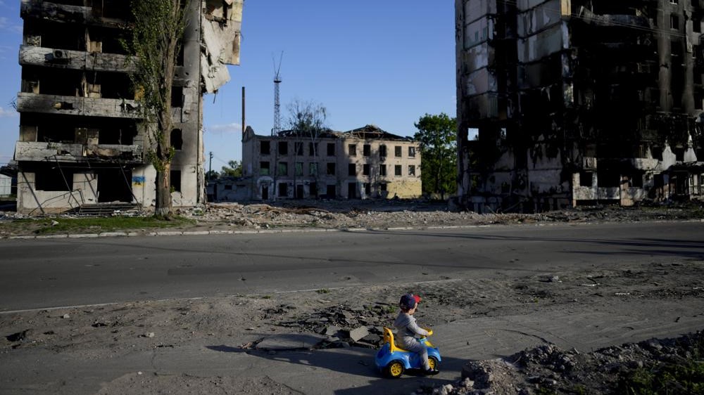 Un niño juega frente a las casas destruidas por los bombardeos en Borodyanka, Ucrania, el martes 24 de mayo de 2022.